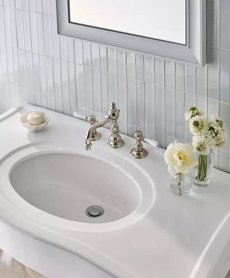 В ванной комнате может применяться белая плитка из различных материалов, в том числе из керамогранита, керамики, натурального камня и цемента.